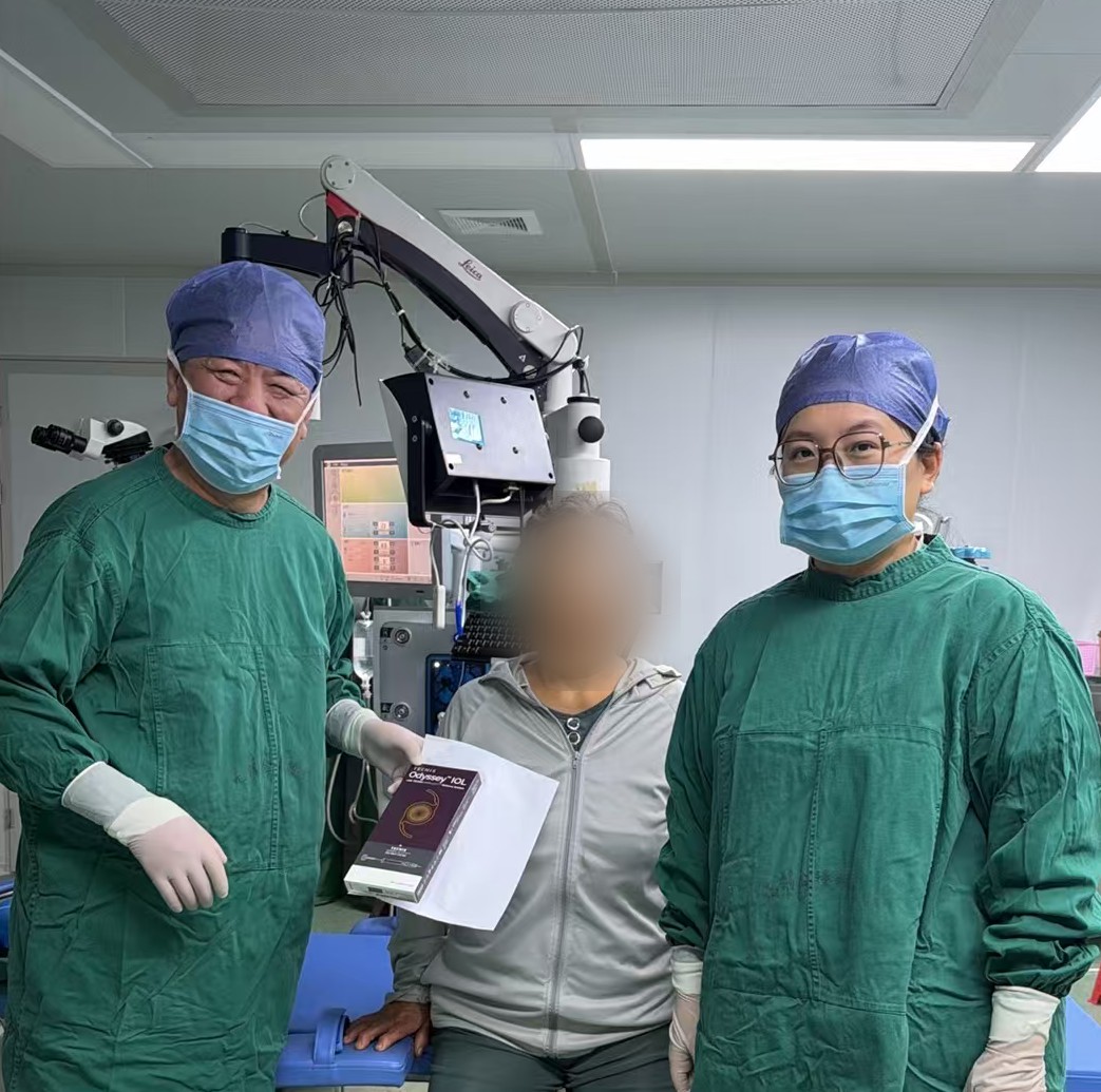 金驿衡院长（左一）与显微眼科手术团队、患者术后合影，患者手持 TECNIS Odyssey 人工晶状体包装盒（患者面部已做隐私处理）